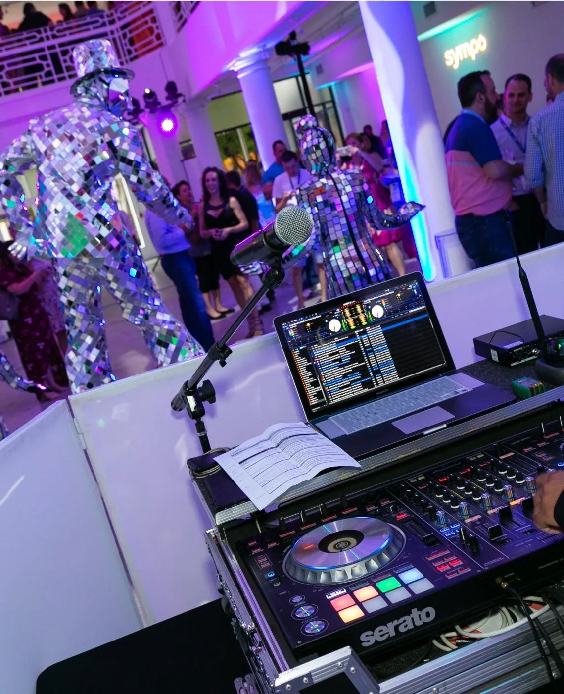 DJ booth and mirror-costumed performers at a live brand event