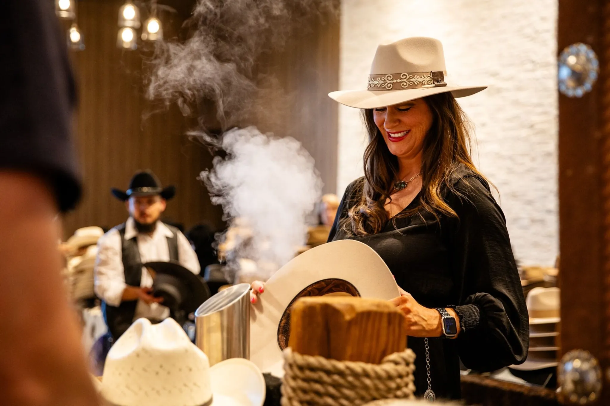 Attendee being fitted for a custom cowboy hat with steam shaping at a Western-themed activation